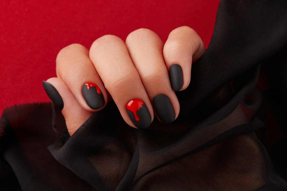 Close,Up,Womans,Hand,With,Halloween,Manicure,On,Red,Background